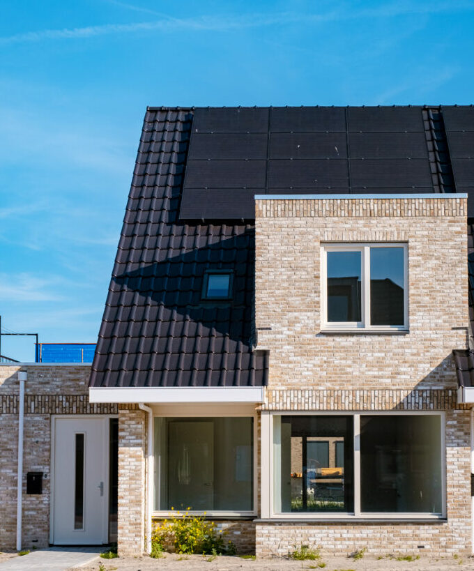 Newly build houses with solar panels attached on roof against a sunny sky Close up of solar pannel Solarpanele von About Solar